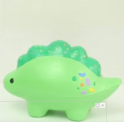 a green plastic toy that looks like a hedgehog with dots on it's head