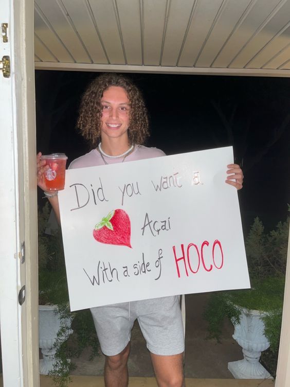 a man holding up a sign that says did you want a aeai with a side of hoco?