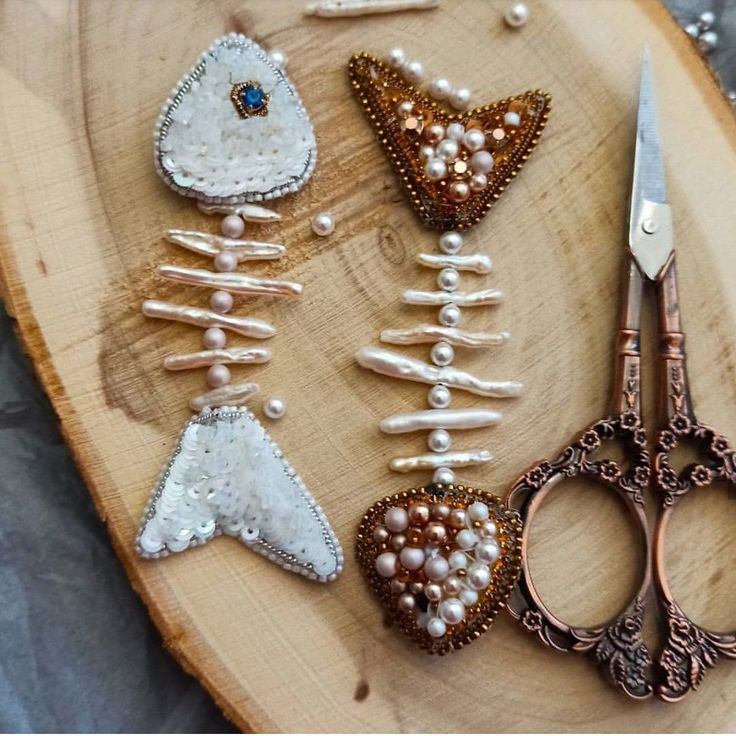 several different types of bead and sequins on a wooden board with scissors