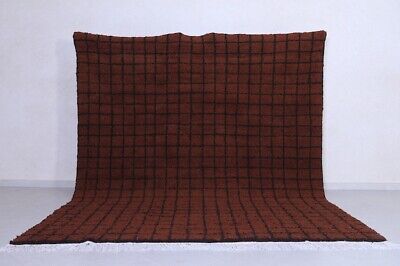 a brown blanket sitting on top of a white floor next to a black and red wall