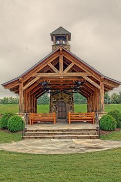 a wooden gazebo with benches in front of it