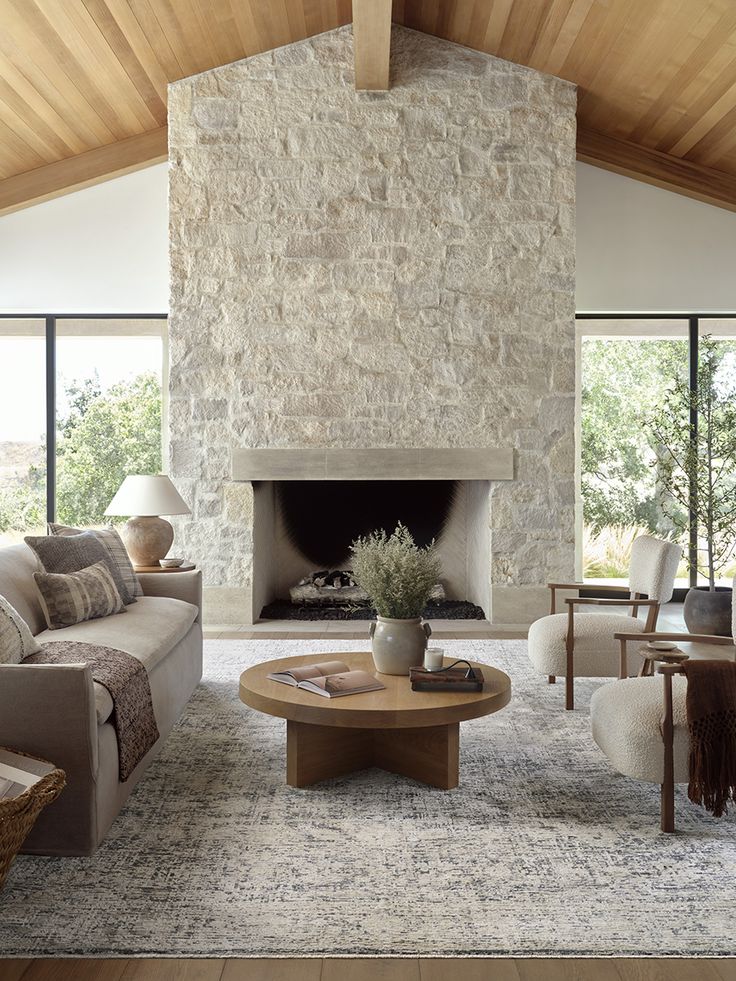 a living room filled with furniture and a fire place in front of a stone fireplace