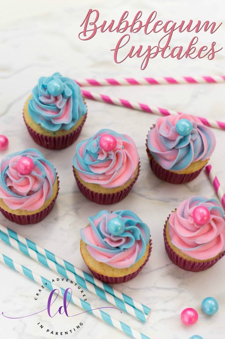 cupcakes with pink, blue and white frosting are on a marble surface