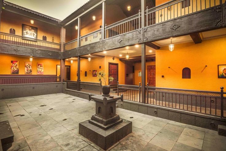 the courtyard of an apartment building with yellow walls and balconies