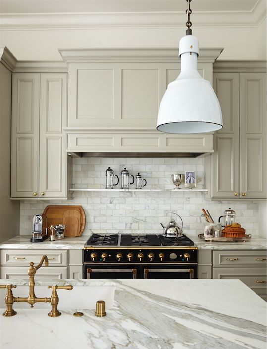 a kitchen with marble counter tops and gold faucets