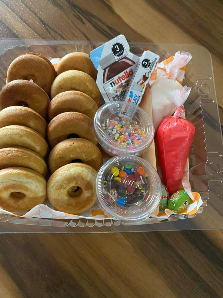 a plastic container filled with donuts and candy