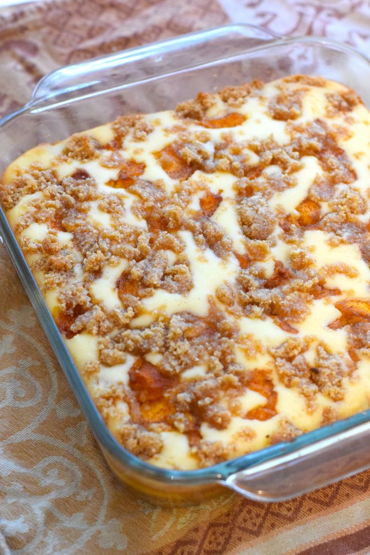 a casserole dish with meat and cheese in it sitting on a tablecloth