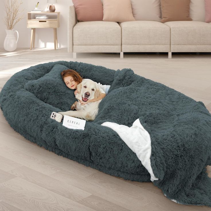 a woman laying on top of a dog bed