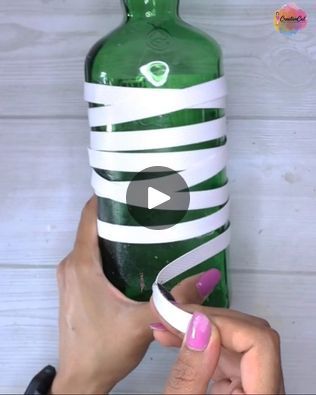 a woman holding a green bottle with white tape on it