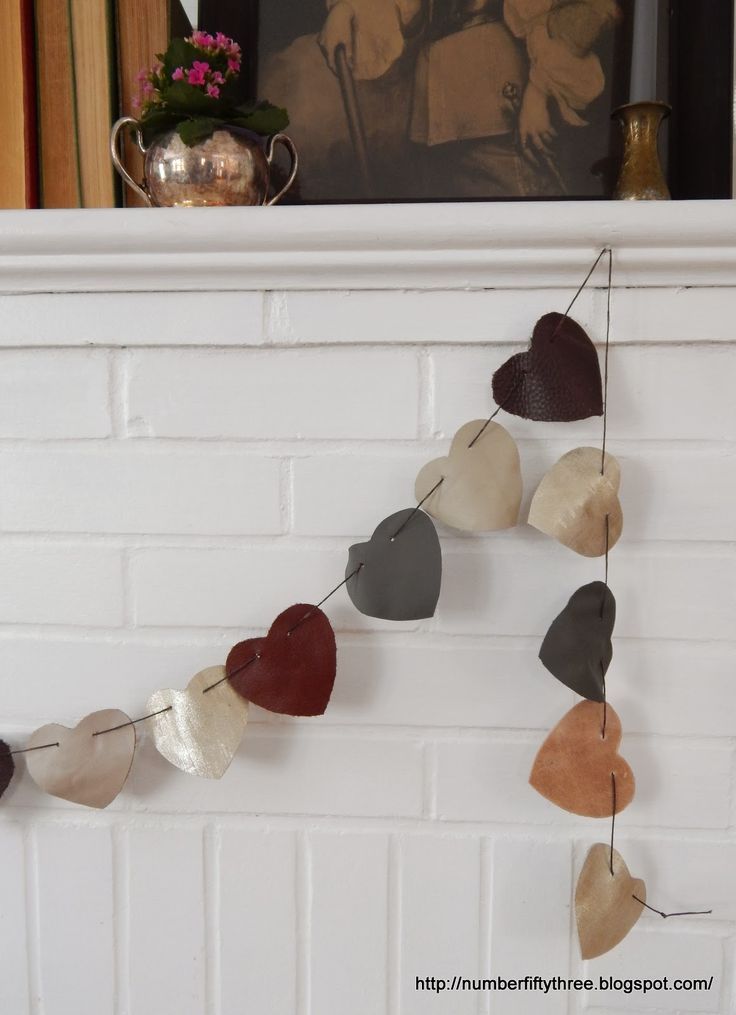 a heart shaped garland hanging from a fireplace