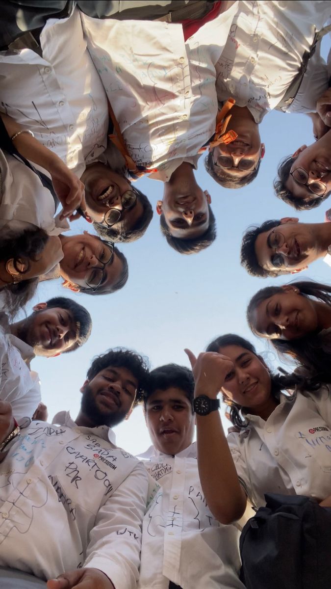 a group of people standing in a circle with their hands on their hipss and pointing at the camera