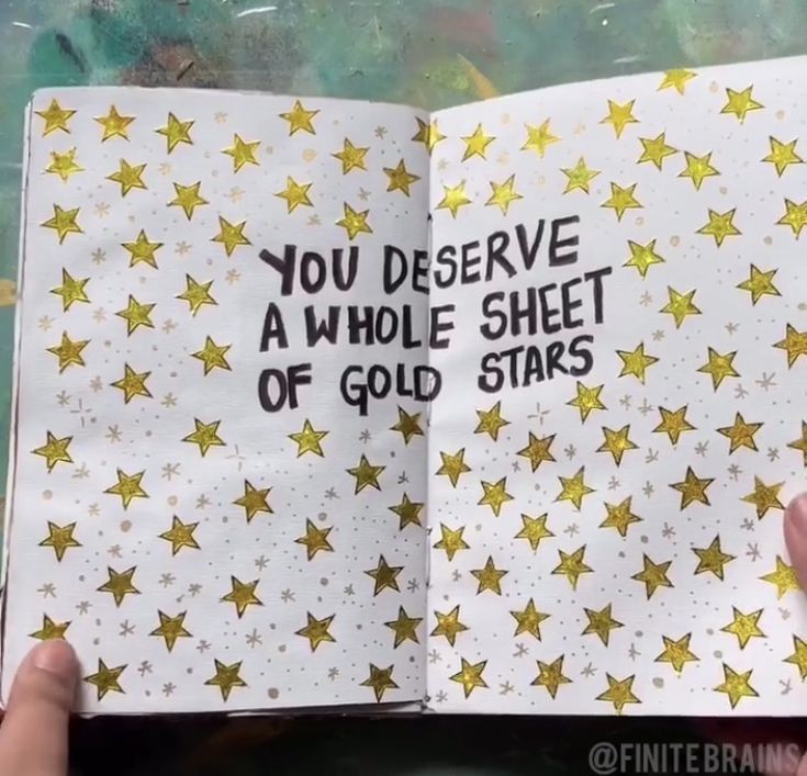 someone is holding an open book with gold stars on it and the words you deserves a whole sheet of gold stars