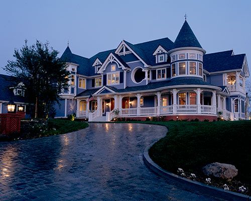 a large house with lots of windows on the front and side of it at night