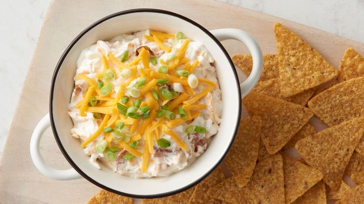 a bowl of dip surrounded by tortilla chips