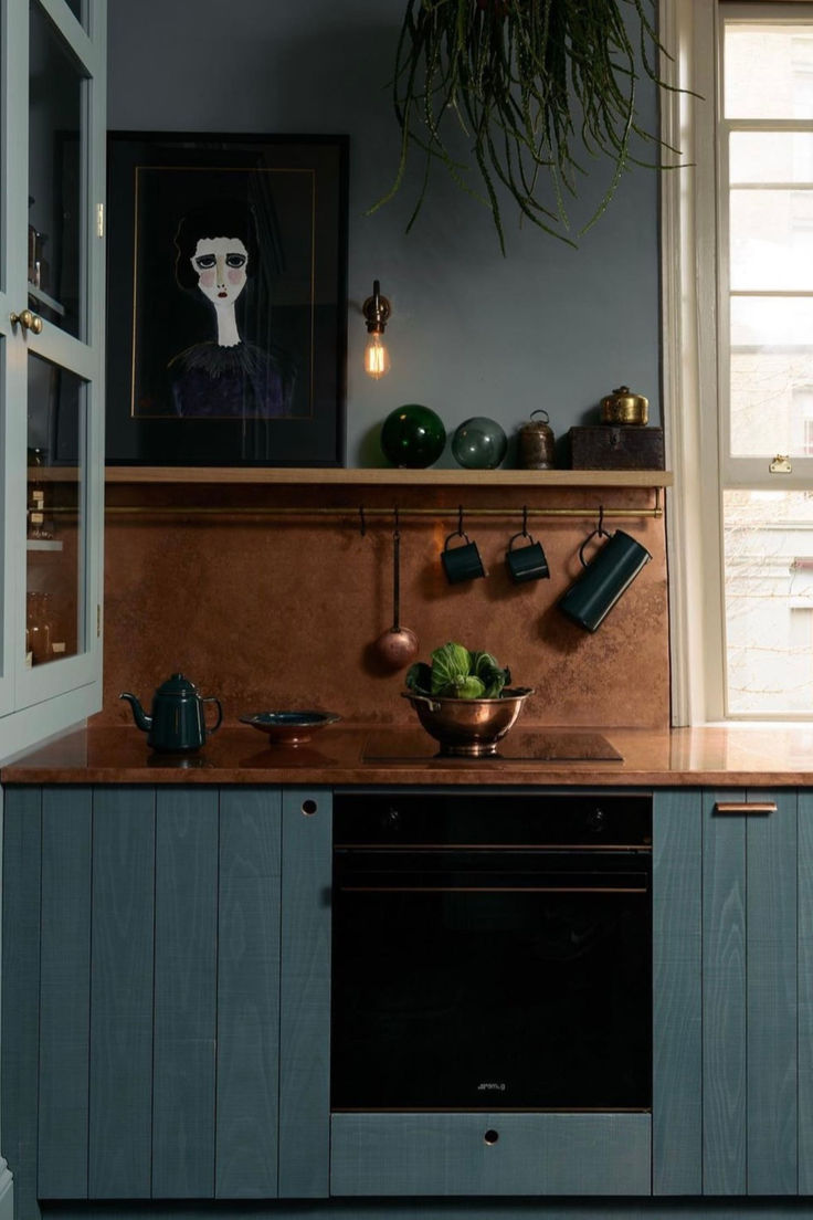 a kitchen with an oven, sink and potted plant on the counter top in front of it