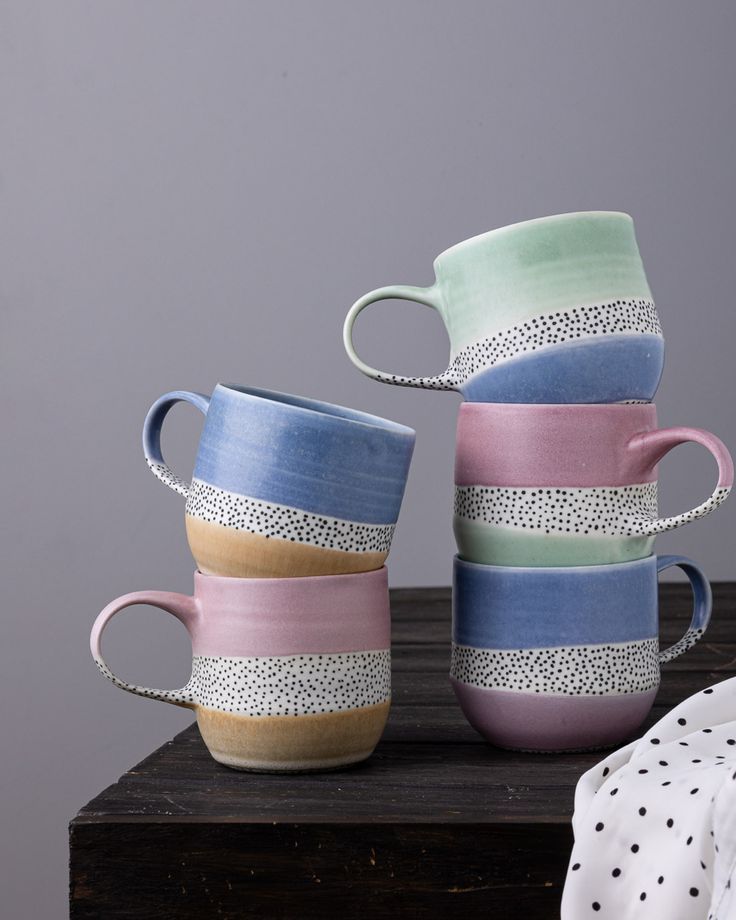 four cups stacked on top of each other with polka dot designs and dots in them