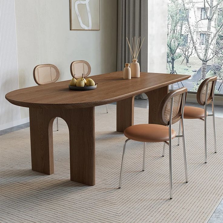 a wooden table with chairs around it in front of a large window and an art work hanging on the wall