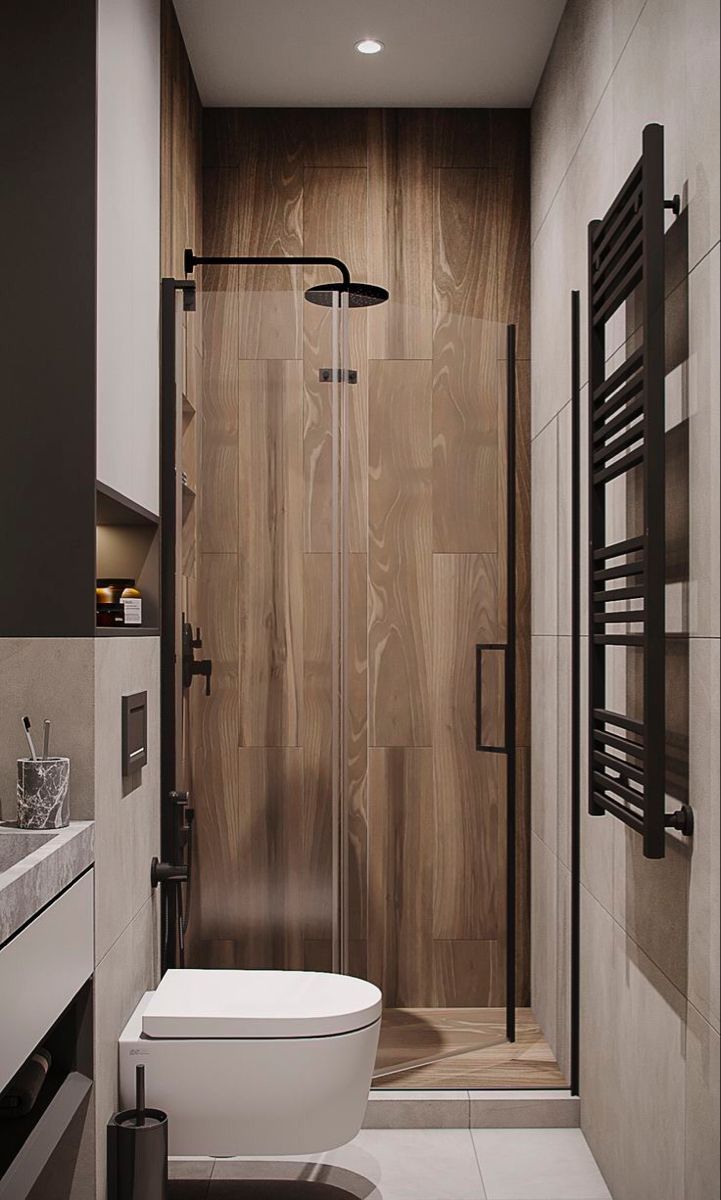 a bathroom with a toilet, sink and shower in it's stall area that has wood paneling on the walls