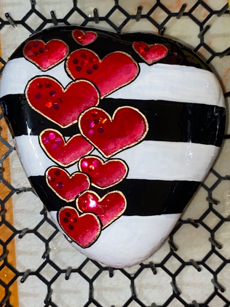 a painted heart on a chain link fence with red and black hearts in the center