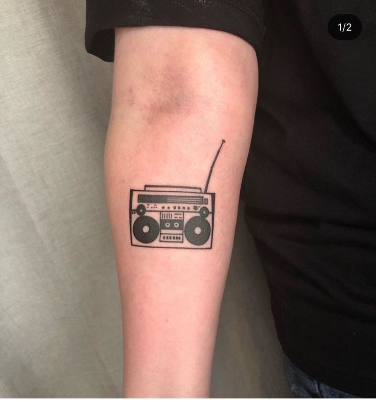 a black and white photo of a radio on someone's arm that has a boombox tattoo on it