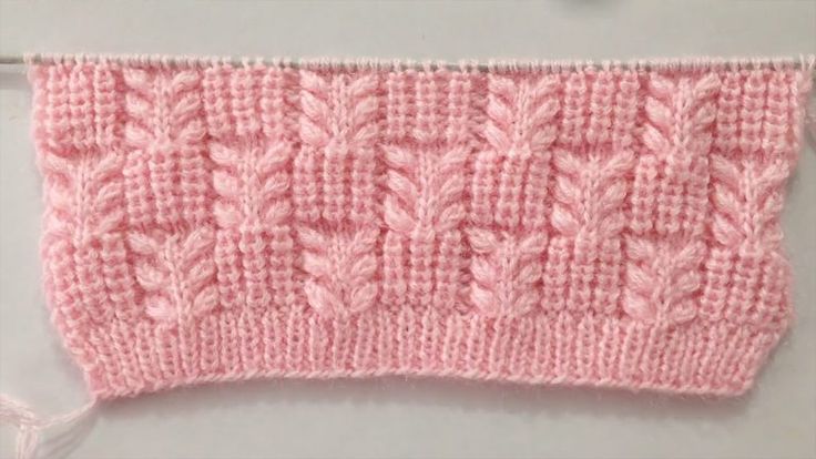 a pink knitted object hanging on the wall