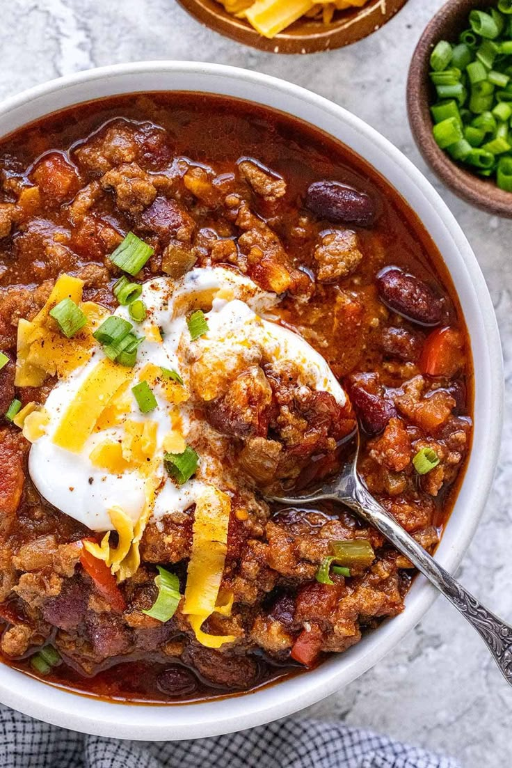 a white bowl filled with chili and eggs