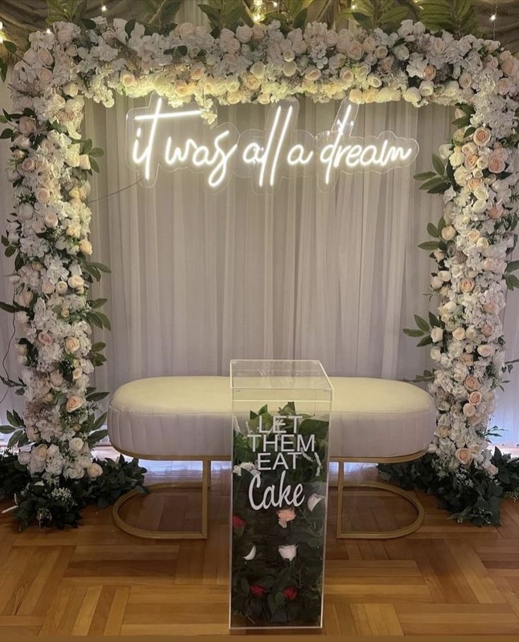 there is a sign that says it was all a dream in front of a floral arch