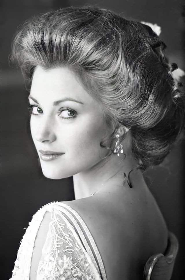 a black and white photo of a woman with her hair up in a low bun