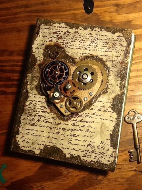 a heart shaped clock with gears attached to it on top of a wooden table next to a key