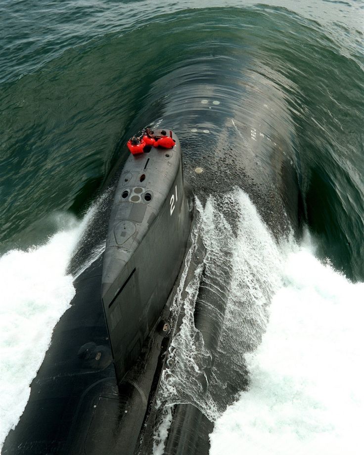 a submarine in the water with its nose out and red lights on it's side