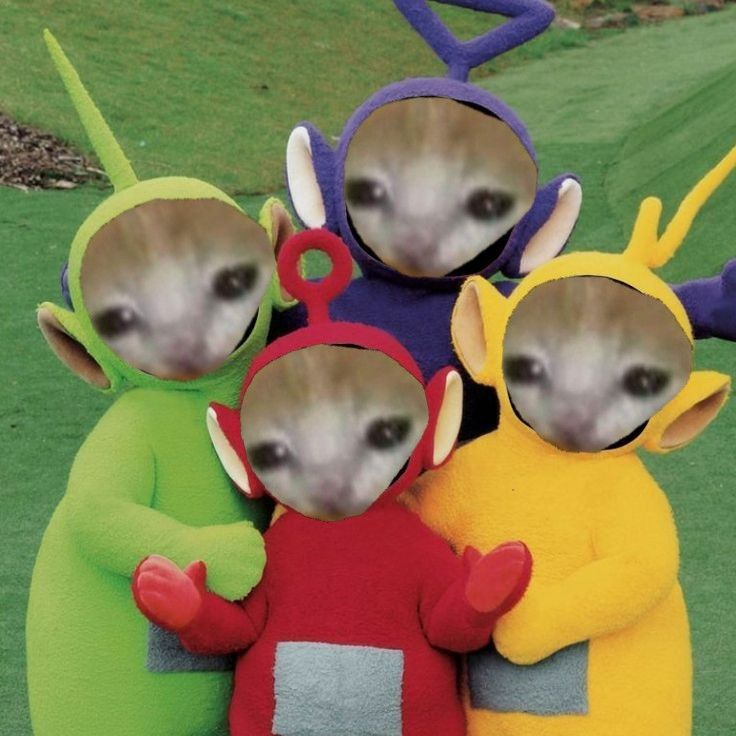 four small stuffed animals are standing in the grass with their heads turned to look like aliens