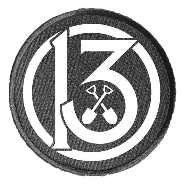 a black and white patch with the number six in it's center surrounded by tools