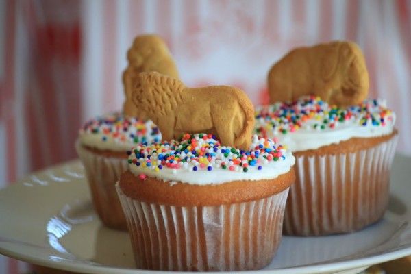 three cupcakes with frosting, sprinkles and dogs on them