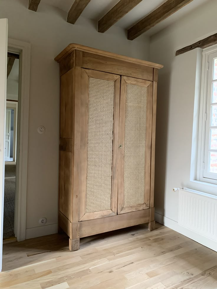 an empty room with a wooden cabinet in it