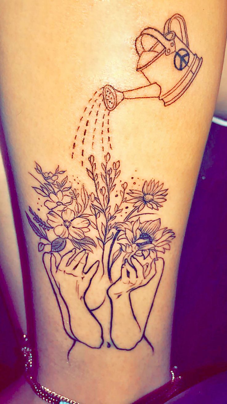 a woman's leg with flowers and watering can tattoo on it