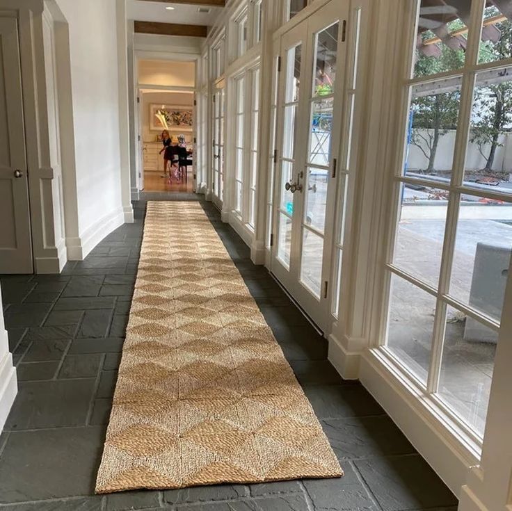 a long hallway with large windows and carpet on the floor