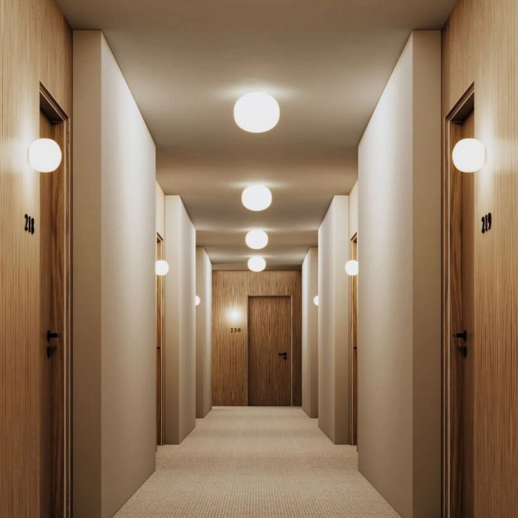 an empty hallway with three lights on either side and two doors open in the middle