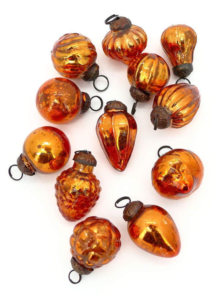 a bunch of orange glass ornaments sitting on top of a white table next to each other