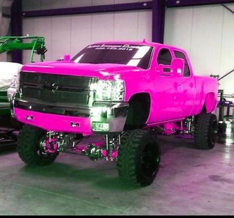 a pink truck is parked in a garage