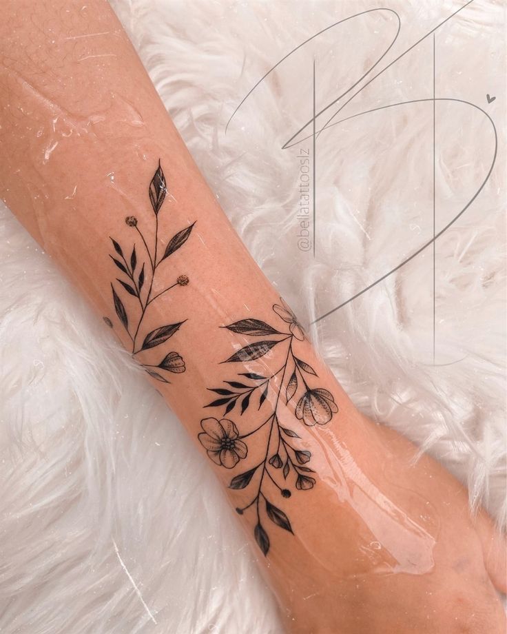 a woman's foot with a flower tattoo on the left side of her leg