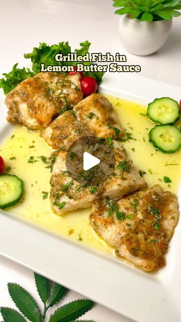 grilled chicken with lemon butter sauce and cucumber garnish on a white plate