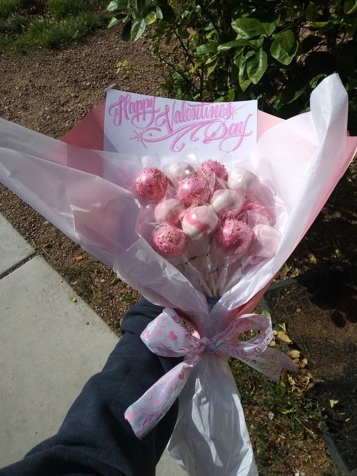 a bouquet of pink and white candies wrapped in cellophane with a happy valentine's day card