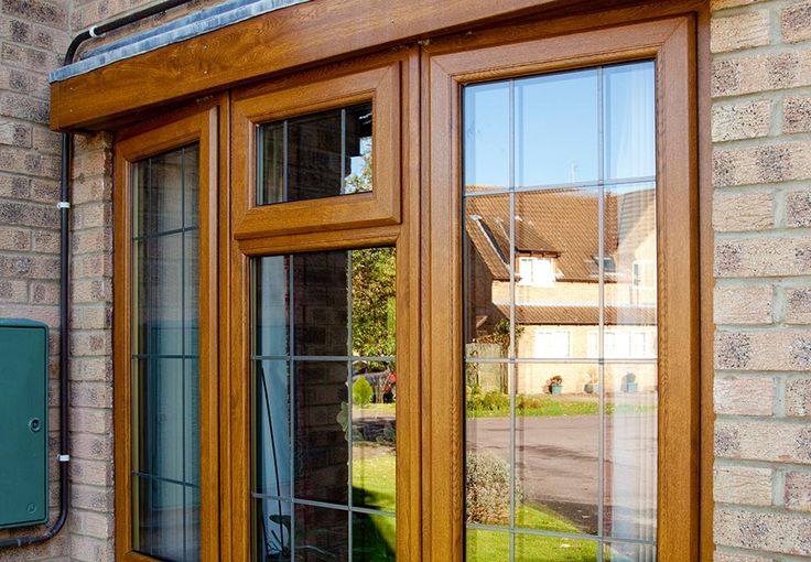 an open window on the side of a brick building with glass panes and wood trim