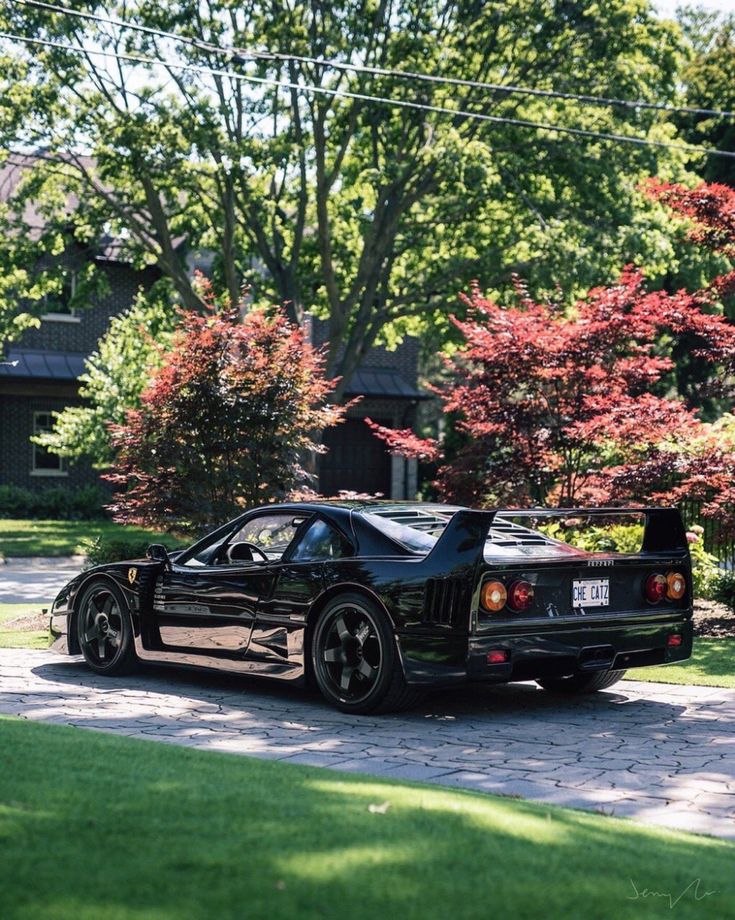 a black sports car parked in front of some trees