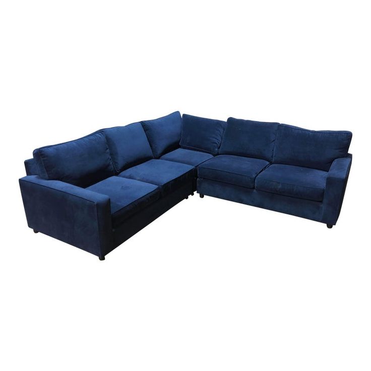 a blue sectional couch sitting on top of a white floor