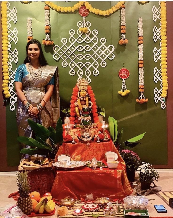 a woman standing in front of a table with food on it and decorations around her