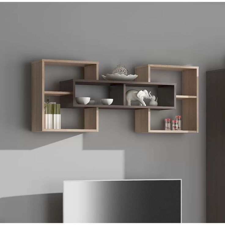 a shelf with some bowls and cups on it in a room that is painted gray