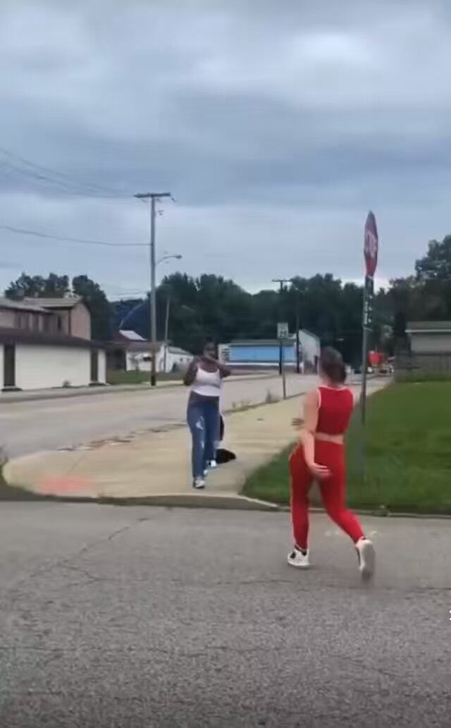 two people are running down the street in red pants and one is wearing white sneakers