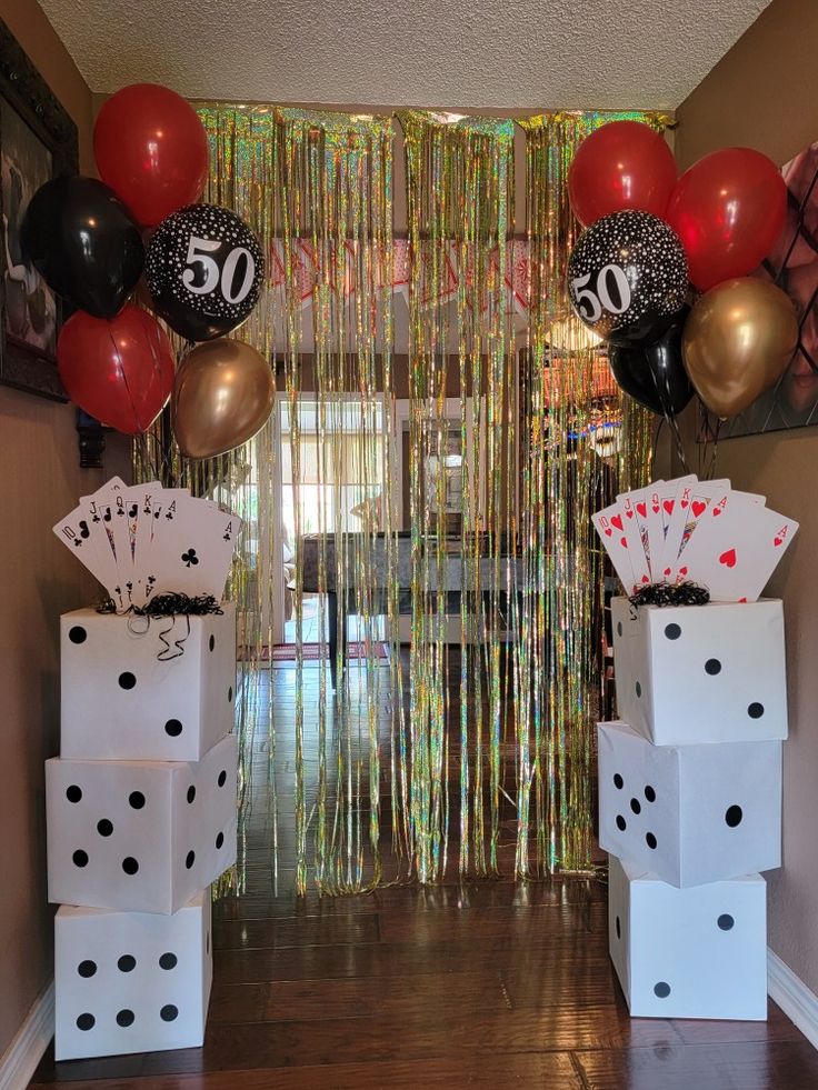 some dice boxes and balloons are in front of the entrance to a casino themed birthday party