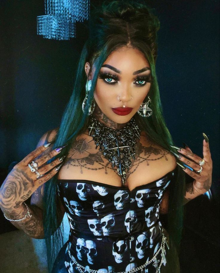 a woman with green hair and tattoos on her chest wearing a corset, choker and bracelets